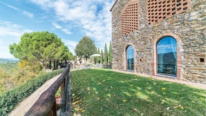 A stone building with large windows and a grassy lawn.