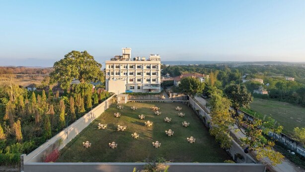 A hotel with a large courtyard, multiple floors, and a view of the surrounding landscape. - DLS Park Grace (Haridwar)