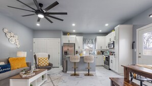 A modern kitchen with white cabinets, a built-in microwave, and a stainless steel refrigerator. - Madison's Masterpiece in Downtown Tulsa-Sleeps 6 (Tulsa)