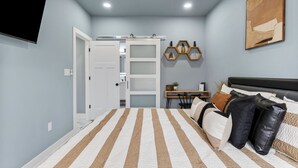 A bedroom with a bed, a desk, and a wardrobe. - Madison's Masterpiece in Downtown Tulsa-Sleeps 6 (Tulsa)