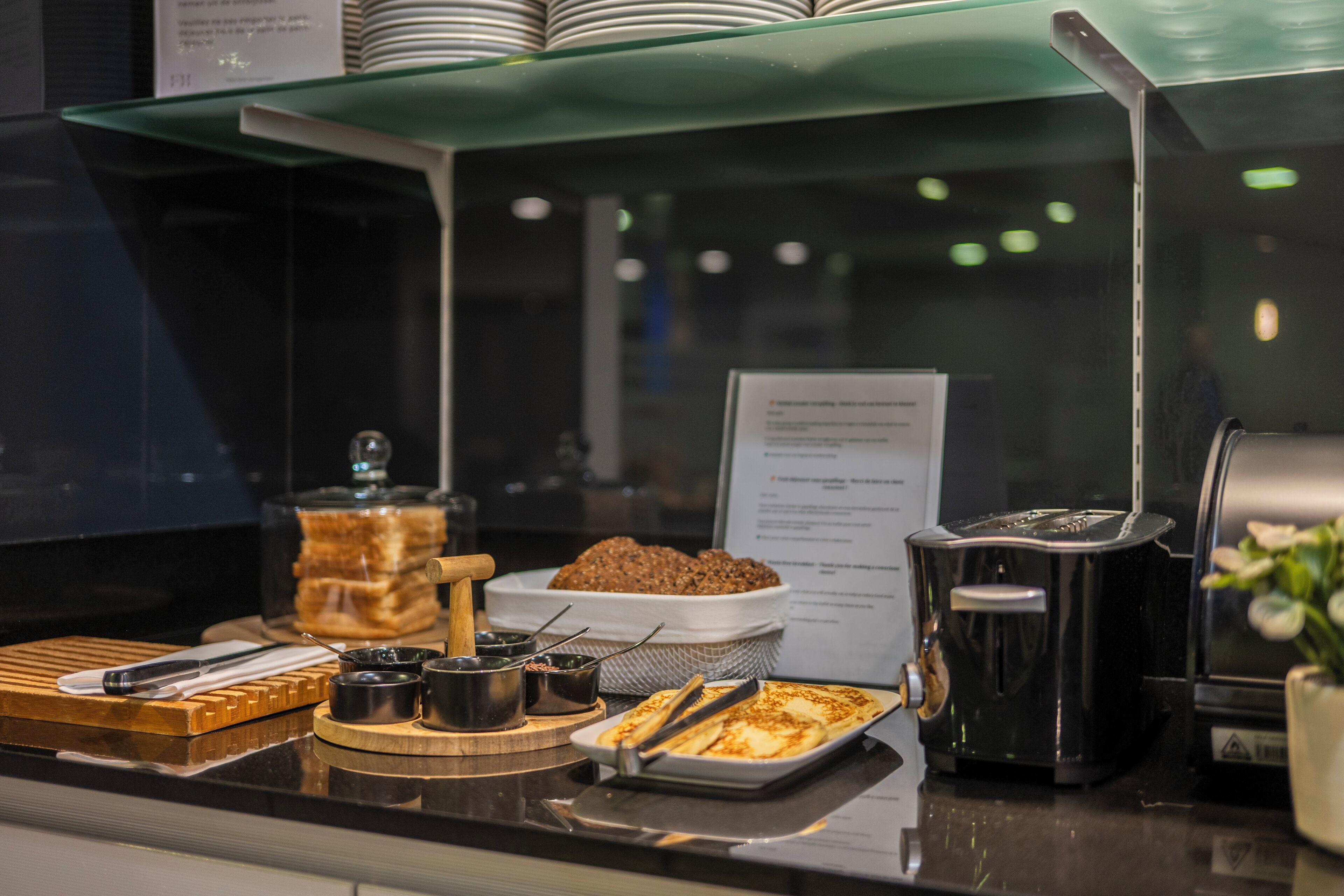 A buffet counter with various food items and condiments.
