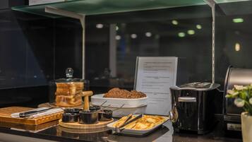 A buffet counter with various food items and condiments.