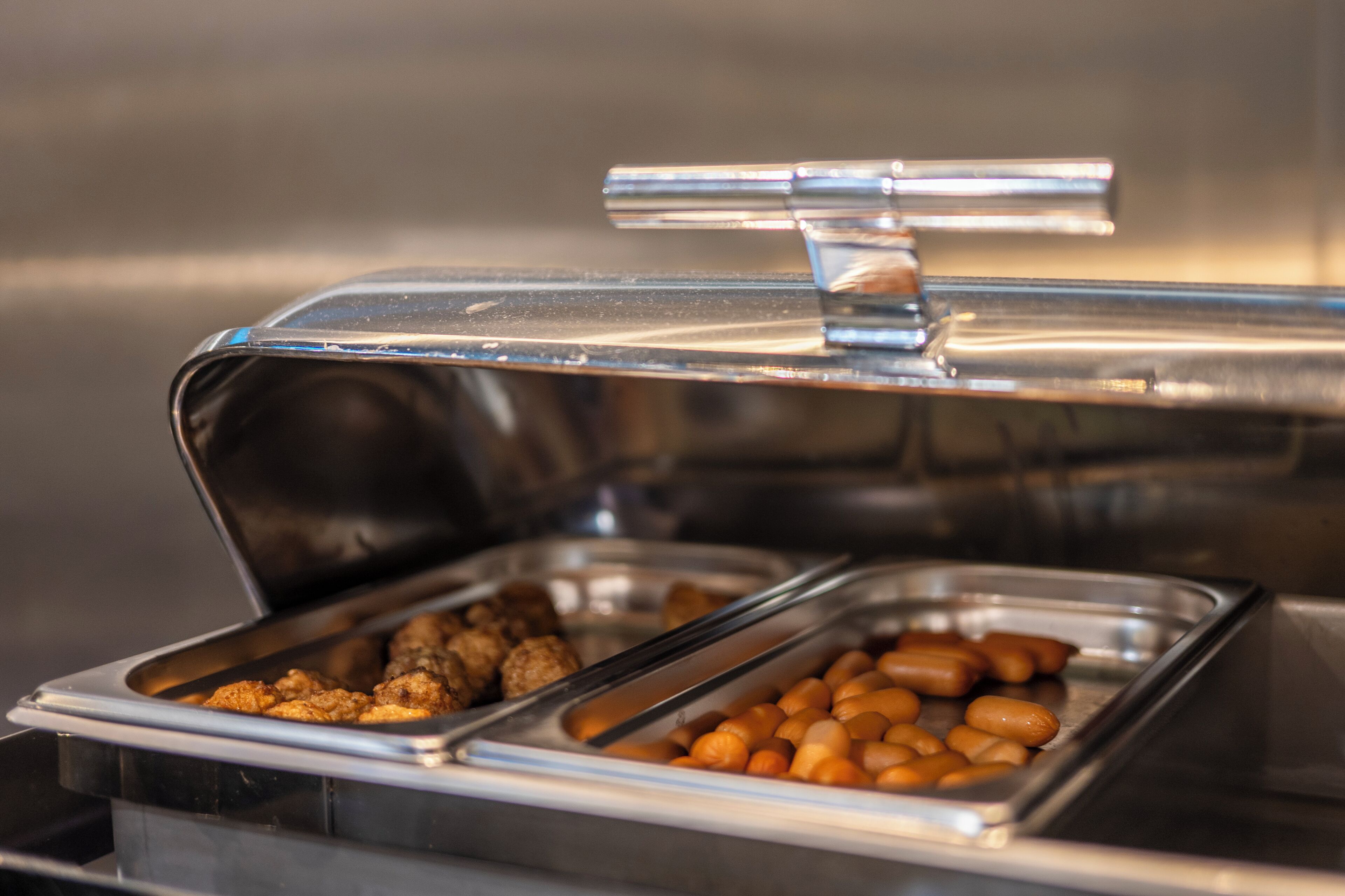 Un bufé con diferentes alimentos en recipientes separados.