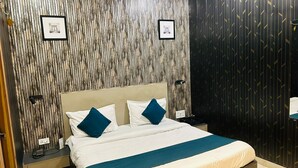 A modern bedroom with a large bed, two nightstands, and a wall with vertical wooden slats. - Hotel Aalishan (Varanasi)