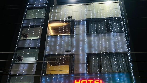 A multi-story building with a sign reading "HOTEL AALISHAN PALACE." - Hotel Aalishan (Varanasi)