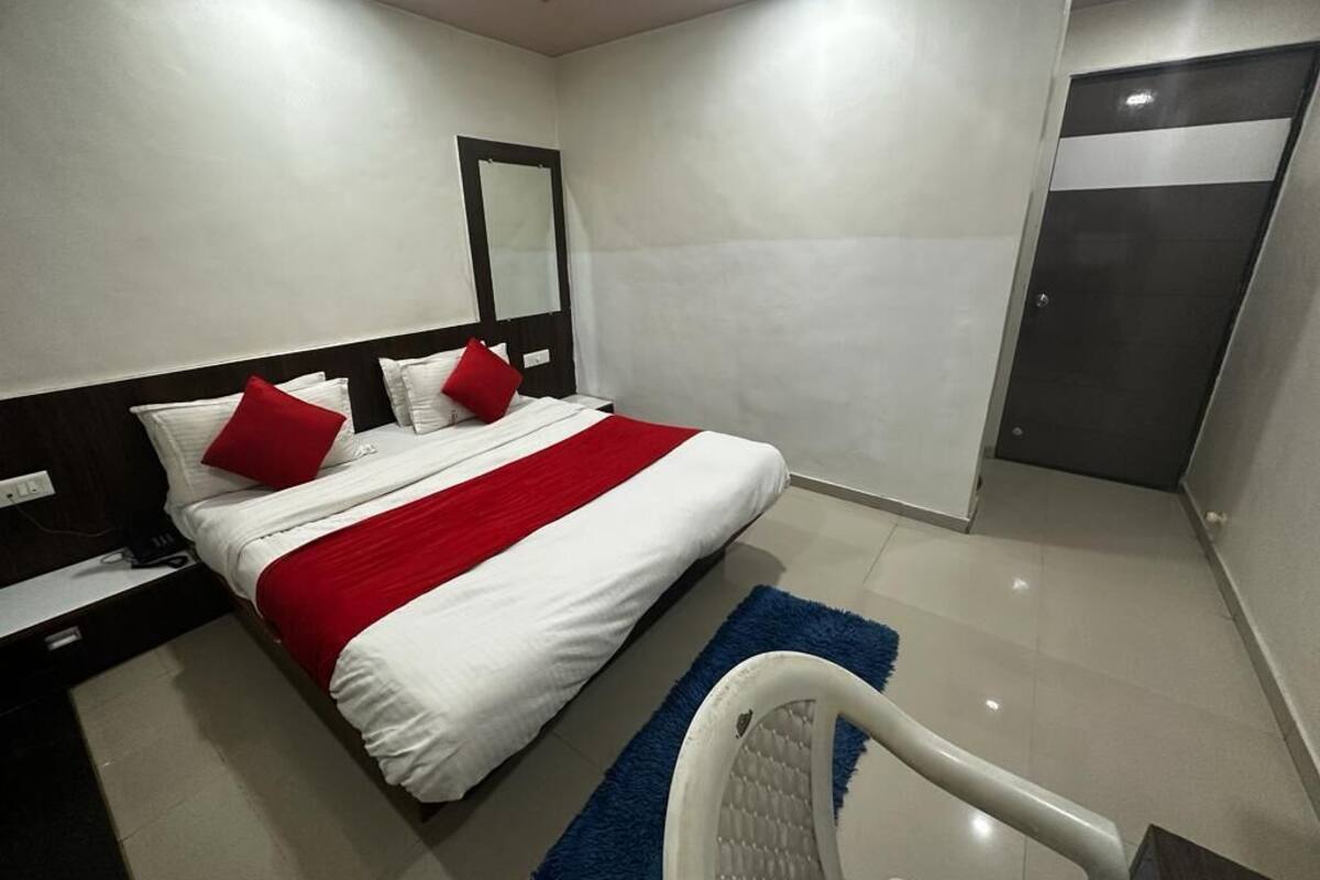 Una habitación de hotel moderna con una cama grande, una mesita de noche, un escritorio y un armario.