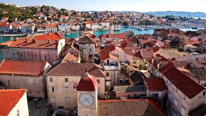 A coastal town with historic buildings, a prominent clock tower, and a marina with boats. - Apartments & Rooms Buble - Studio with terrace (Trogir)