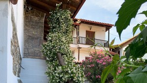 A staircase with white walls and stone steps, surrounded by lush greenery and flowering plants. - Beautiful Petrino 1880 (Agios Nikolaos)