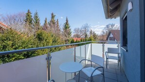 A balcony with a glass railing, two white tables, and metal chairs. - Dießen, Ammersee-Nest, new, bright, 90sqm, 2 bedrooms, balcony, parking spaces, premium (Dießen am Ammersee)