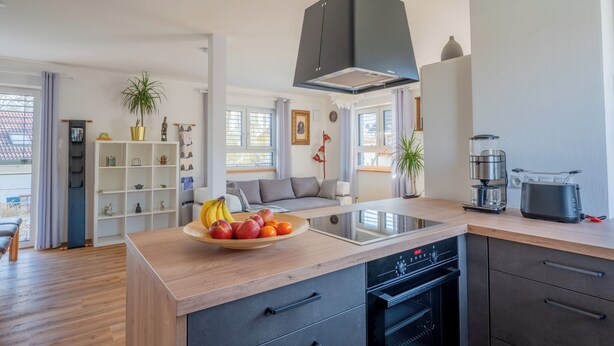 A modern kitchen with a central island, built-in oven, and a coffee maker. - Dießen, Ammersee-Nest, new, bright, 90sqm, 2 bedrooms, balcony, parking spaces, premium (Dießen am Ammersee)