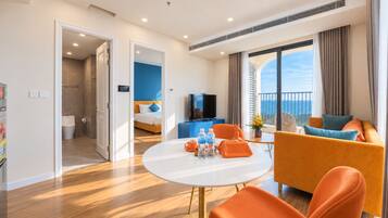Una habitación de hotel moderna con balcón, zona de comedor y baño independiente.