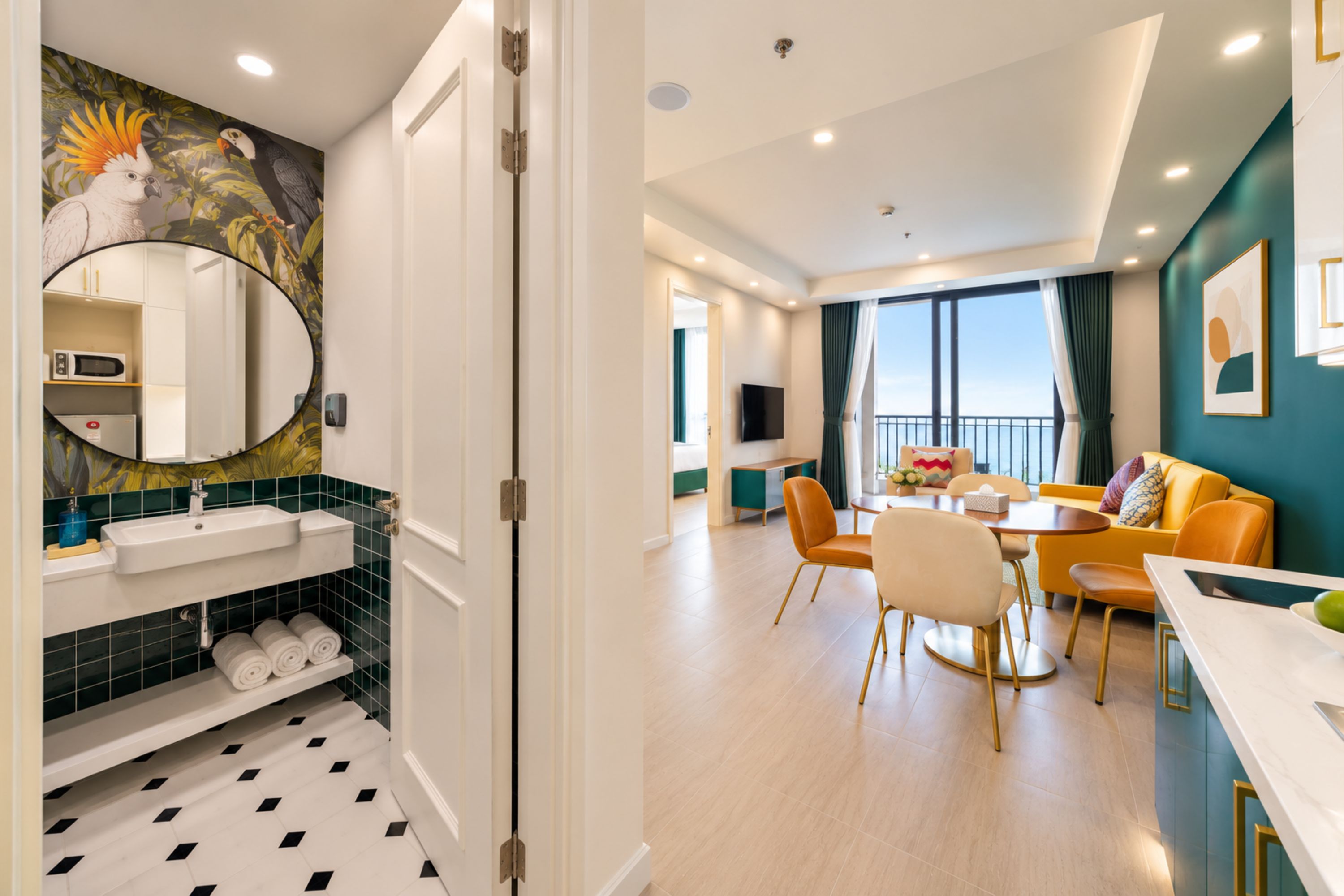 A modern hotel room with a bathroom, dining area, and balcony.