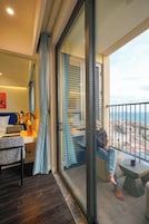 Un dormitorio moderno con un amplio ventanal corredera que da a un balcón.