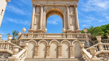 Une entrée imposante, avec une grande arche, des marches en pierre et des colonnes de style classique.