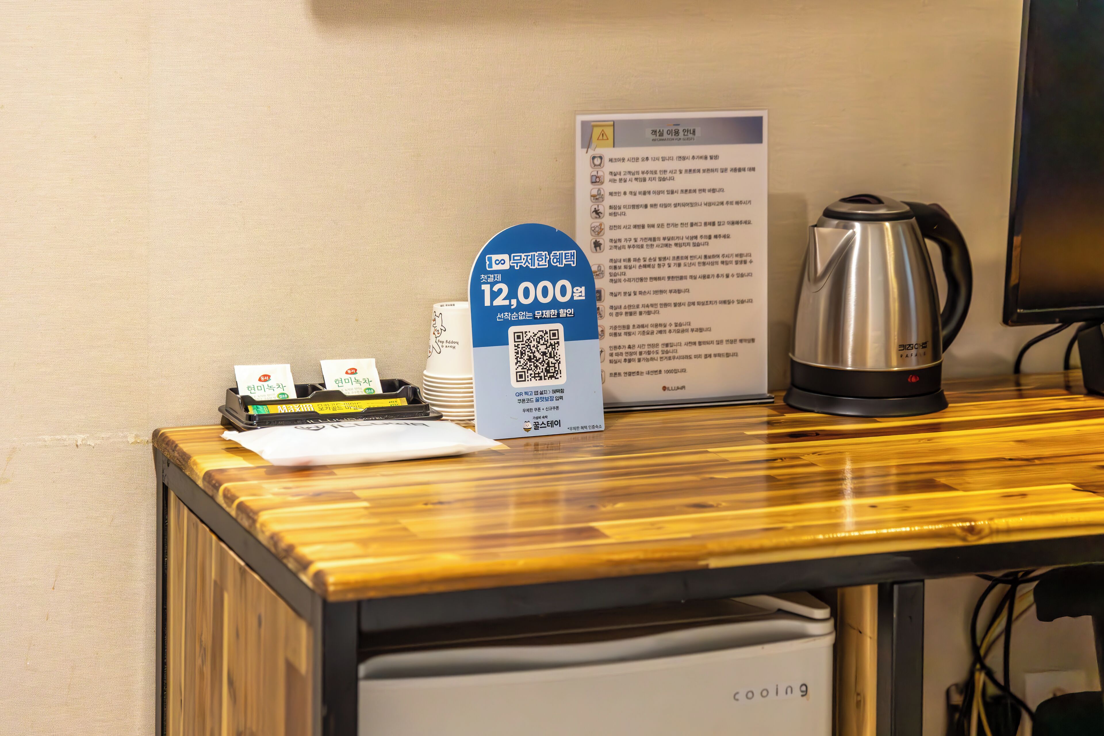 A hotel reception desk with a coffee maker, a QR code sign, and a menu board.