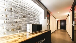 A hotel reception area with a brick wall, a wooden counter, and a sign reading "Motel Illuwa". - ILLUWA-M (Seoul)