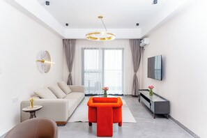 Deluxe Apartment, 3 Bedrooms, Balcony, City View | Living area | 50-inch Smart TV with satellite channels - Greenland Apartment by Link (Kigali)