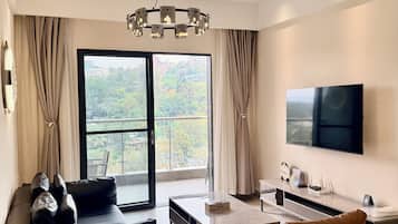 Una sala de estar moderna con sofá, sillón, mesa de centro y un televisor de pantalla plana montado en la pared.