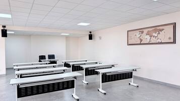 Un aula con varias mesas, un proyector y un mapa mundial en la pared.