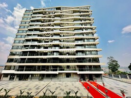 Un edificio de varios pisos con balcones y una alfombra roja que conduce a la entrada.