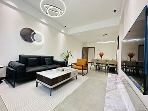 Deluxe Apartment, 2 Bedrooms, Balcony, City View | Living area | 50-inch Smart TV with satellite channels - Greenland Apartment by Link (Kigali)