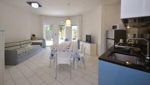 A modern kitchen with a dining area, white walls, and a large window. - Sophistication and stylish vacation apartment (Bibione)