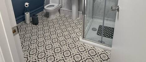 A bathroom with a shower, toilet, and sink.