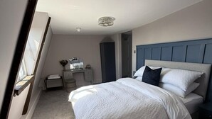 A bedroom with a bed, a desk, and a dresser. - The White Hart (Melksham)