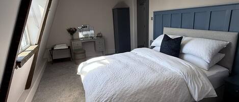 Un dormitorio con cama, escritorio y cómoda.