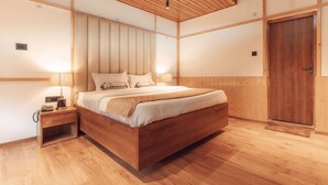 Une chambre à coucher avec un cadre en bois, comprenant un lit, des tables de chevet et une porte en bois.