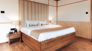 Une chambre à coucher avec un cadre en bois, comprenant un lit, des tables de chevet et une tête de lit.