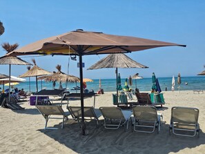 A beach with sun loungers, umbrellas, and a clear view of the sea. - Beachfront ``Blue Wave SPA Villa`` in a Private Villa Resort (Durrës)