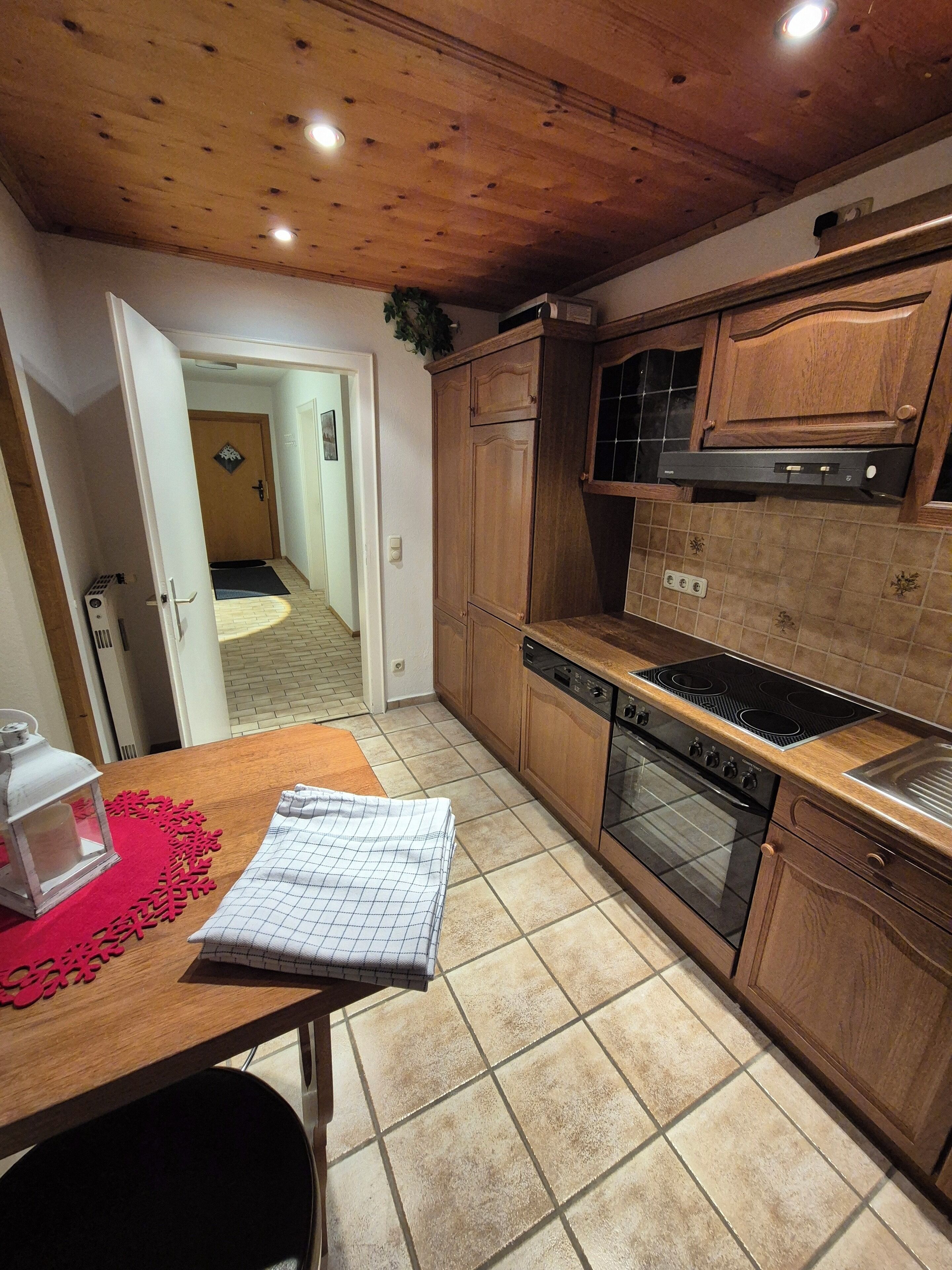 Una cucina con mobili in legno, un fornello e una lavastoviglie.