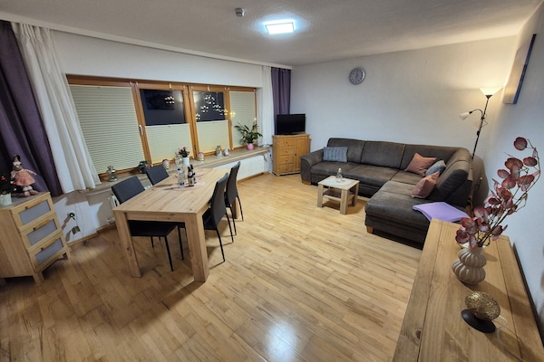 Wohnzimmer mit Esstisch Couch und TV. Blick in Richtung Süden