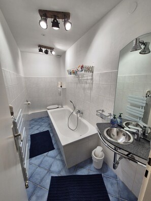 Chuveiro, secador de cabelo, toalhas de banho, papel higiênico