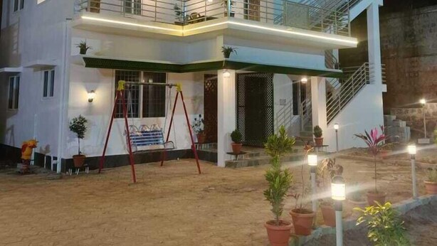 A two-story building with a balcony and a staircase leading to an upper level. - Rithu's inn (Tirupattur)