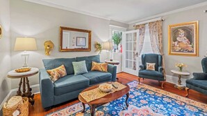 Ein Wohnzimmer mit einer Couch, Sesseln, einem Couchtisch und einem gemusterten Teppich.