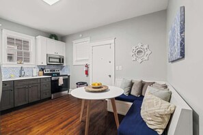 A compact kitchen with a dining table, a microwave, and a stove.