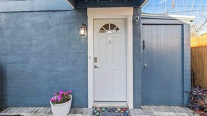 A house with a white door, a welcome mat, and a potted plant. - Mid-Century Modern Riverside - Team Joseph Ellen (Jacksonville)