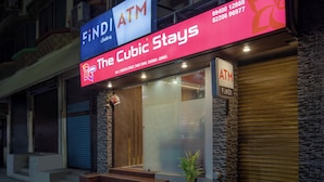 En byggnad med en skylt som visar texten ”The Cubic Stays” och en skylt för en bankomat.