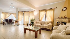 A spacious living room with a sofa set, a coffee table, and a dining area with a table and chairs. - Villa Tsikkos Pende in Argaka (Argaka)