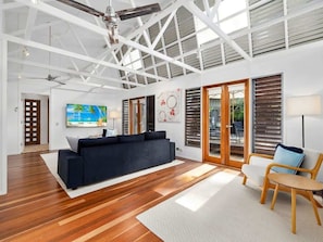 A spacious living area with a black sofa, a wooden coffee table, and a TV.