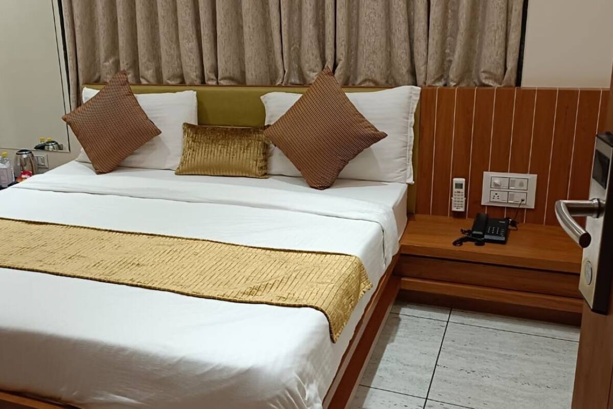 A hotel room with a bed, bedside table, and a telephone.
