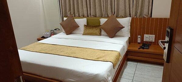 A hotel room with a bed, bedside table, and a telephone. - HOTEL DIAMOND (Diu)
