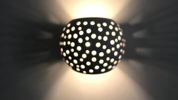 A spherical light fixture with a pattern of evenly spaced holes.