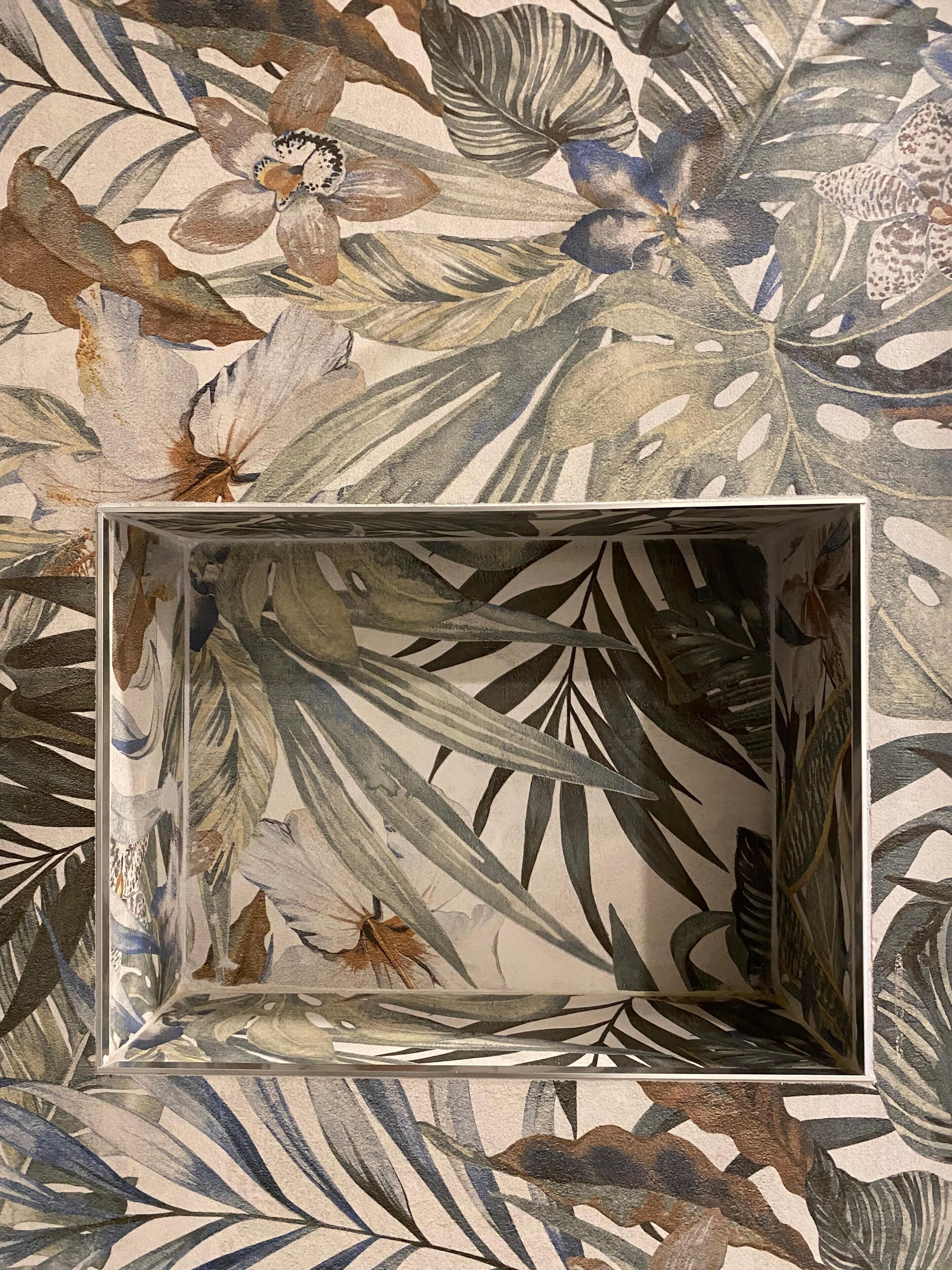A framed artwork with a tropical leaf pattern.