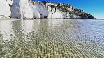 Una spiaggia nelle vicinanze, sabbia bianca, lettini da mare, ombrelloni