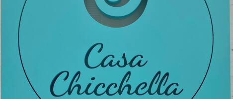 Logotipo con el texto 'Casa Chicchella' y 'Experiencia Auténtica' sobre un fondo color turquesa.