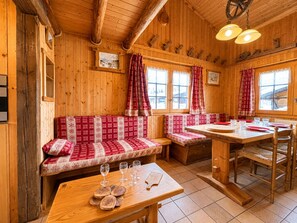 Ein Holzblockhaus Innenansicht mit Bank, Tisch und Essbereich.