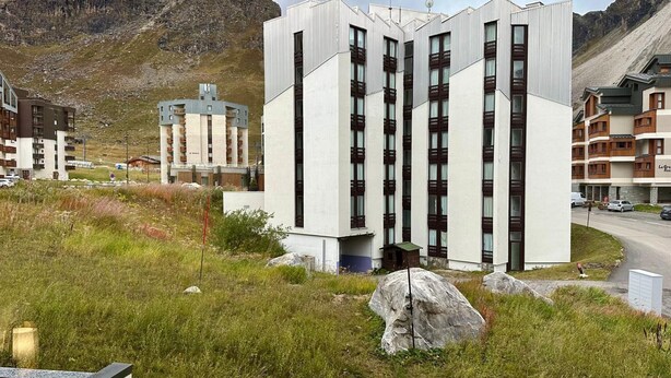 A modern hotel with a central tower and multiple smaller buildings, surrounded by mountainous terrain. - Tignes: Apartment 6 pers, 41 sqm, Slope View (Tignes)